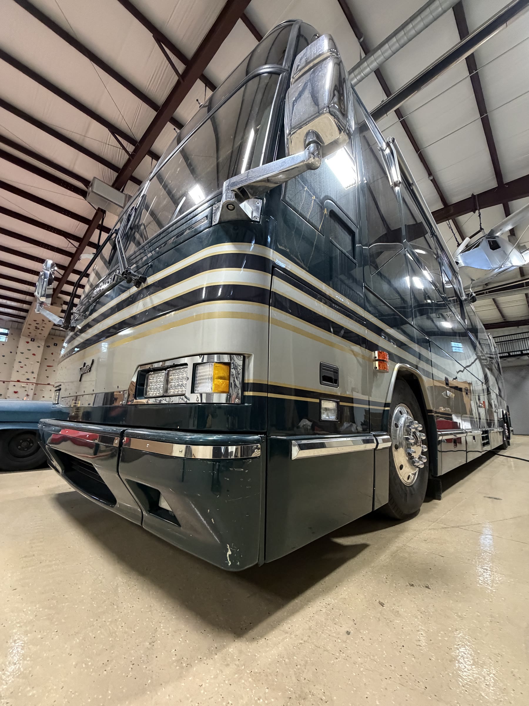 Front three-quarter view of the Prevost coach in hangar